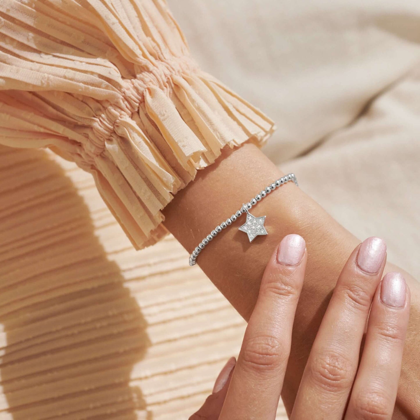 Model wearing silver bracelet with a star set with CZ stone