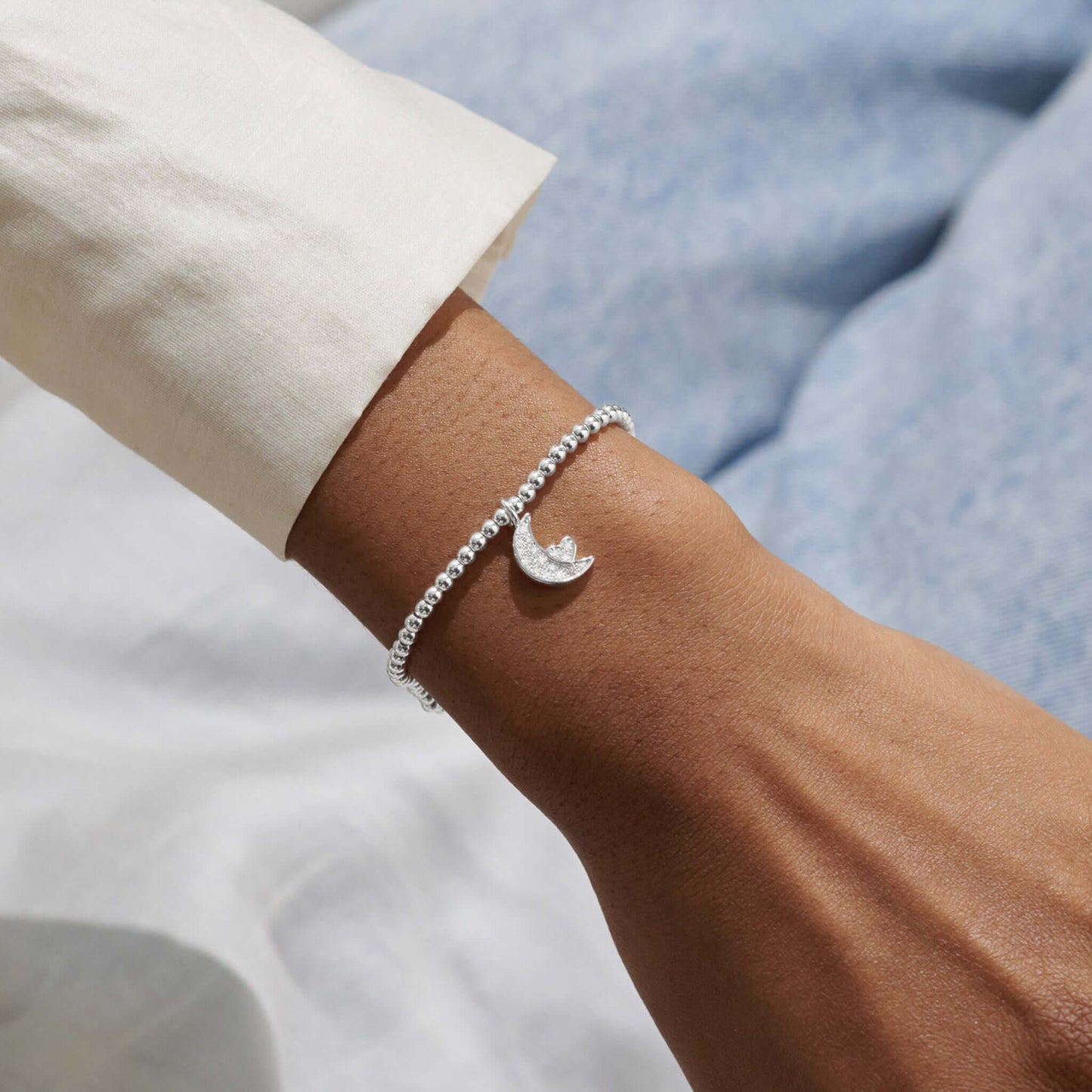 Model with silver bracelet with a CZ moon and heart