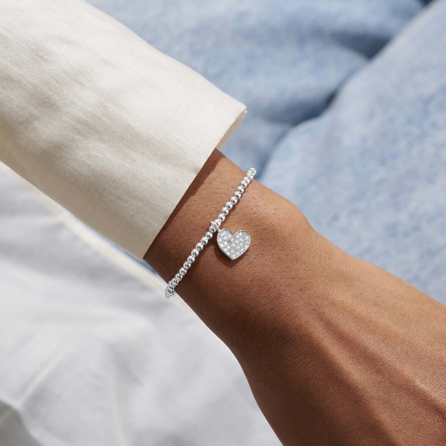 Model wearing silver bracelet with a heart and CZ stones