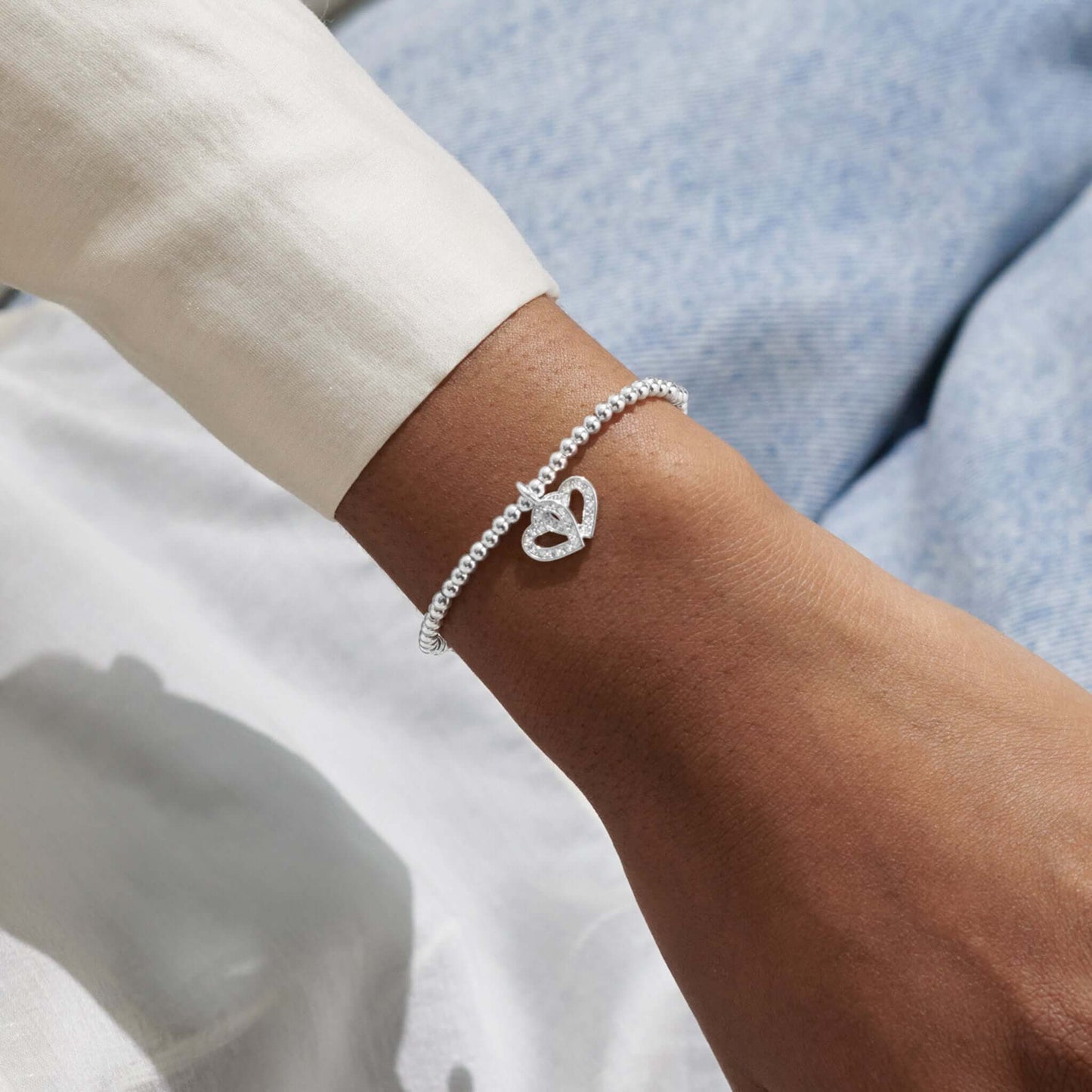 Model wearing silver bracelet with double hearts and CZ stones