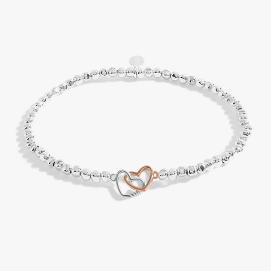 A silver beaded bracelet with rose gold and silver interlinking hearts