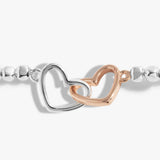 Detail of a silver beaded bracelet with rose gold and silver interlinking hearts