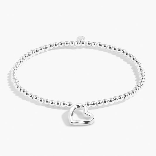 A silver beaded bracelet with a silver wavy heart