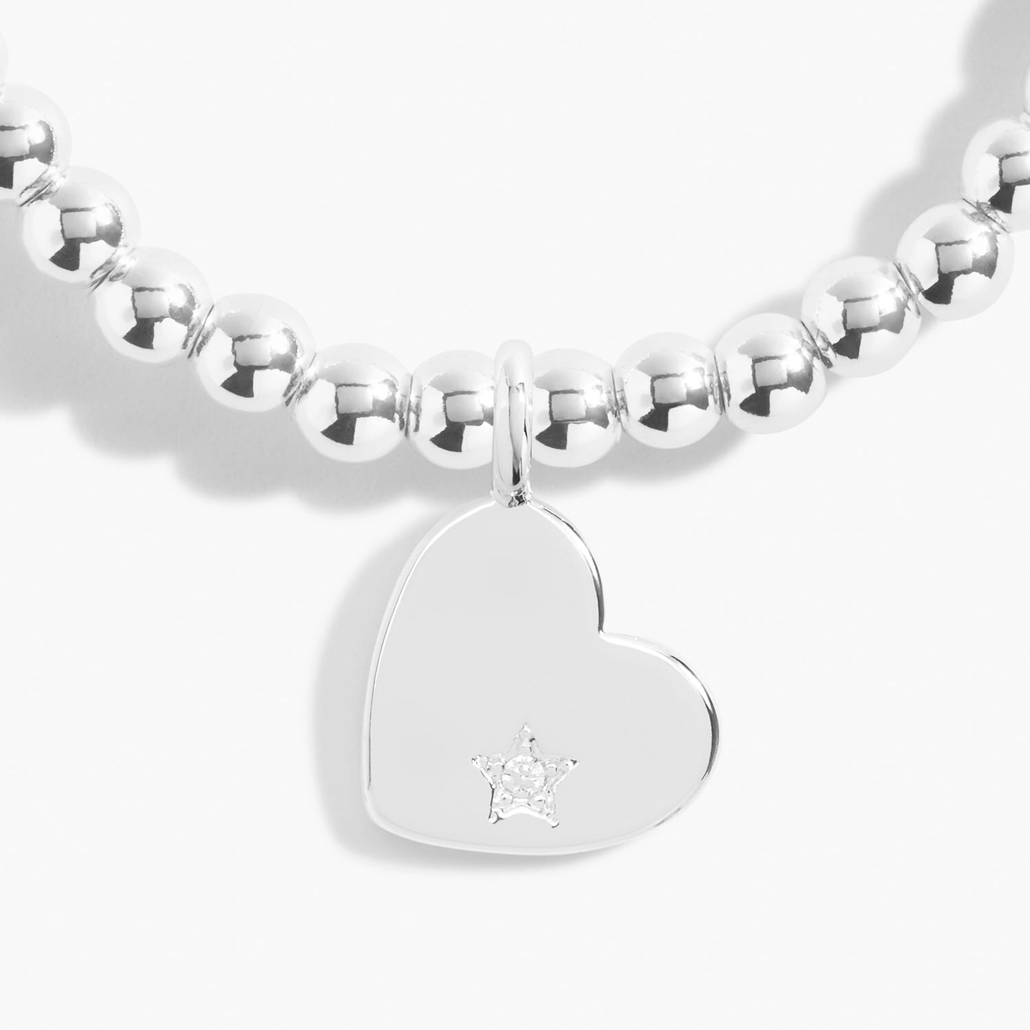 Detail of a silver beaded bracelet with a silver heart with a CZ stone 