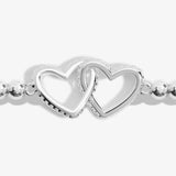 Detail of a silver beaded bracelet with a two silver interlocked hearts