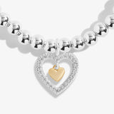 Detail of silver beaded bracelet with silver CZ and gold hearts charm on a sentiment card 