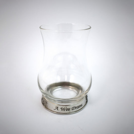 A whisky glass with a pewter base engraved with the words 'A Wee Dram'