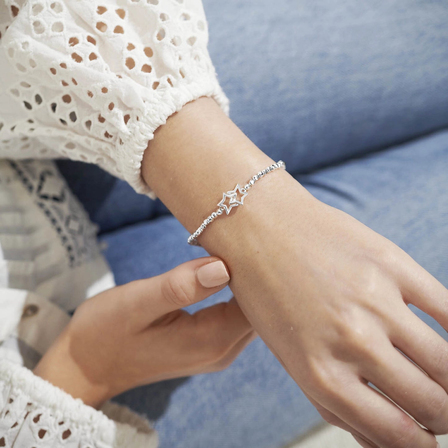 Model wearing a silver beaded bracelet with silver interlinking circles
