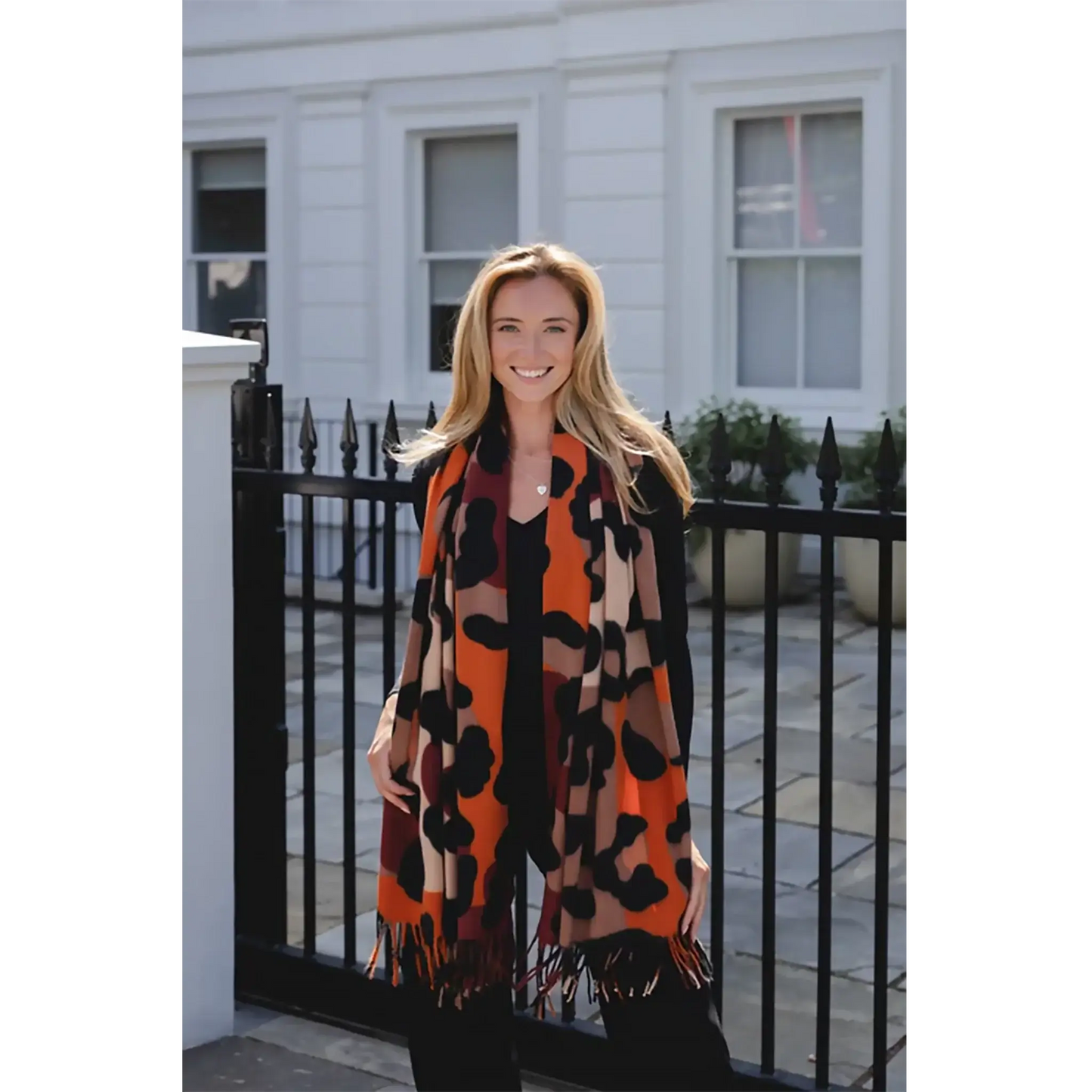 Model wearing animal print scarf in natural colours with tassel trim