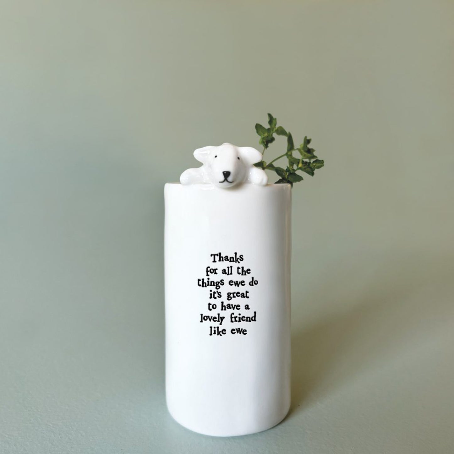 A cylinder white vase with a little sheep and phrase