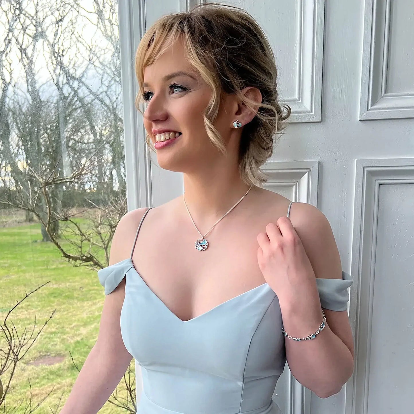 Model wearing earrings and necklace from the Arctic Stream jewellery collection by Sheila Fleet