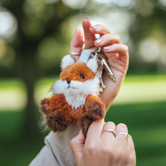 Model holding a plush fox keyring