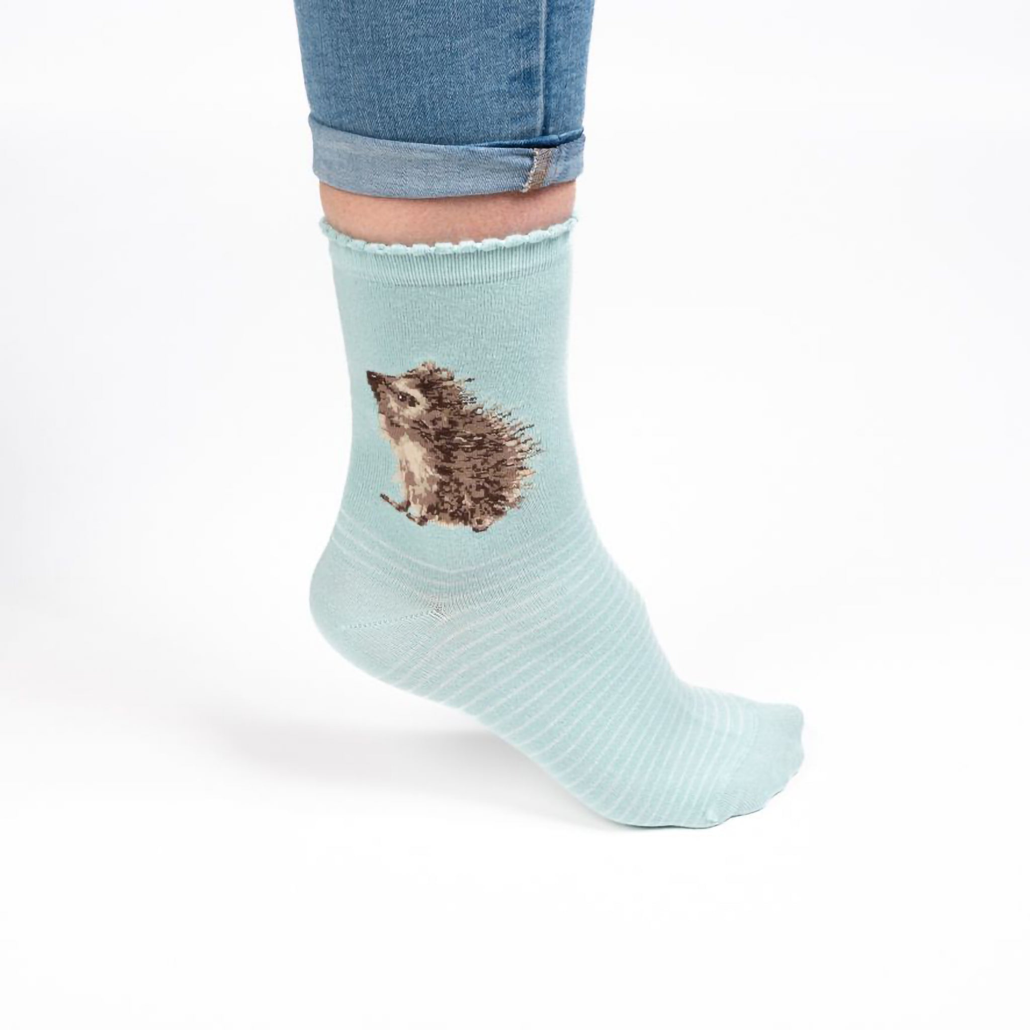 A model wearing a pair of mint green socks with a hedgehog picture and white stripes