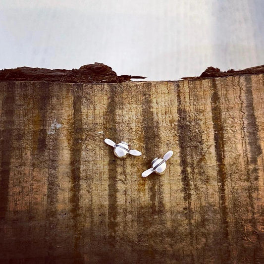 Silver stud earrings shaped like little flying bees