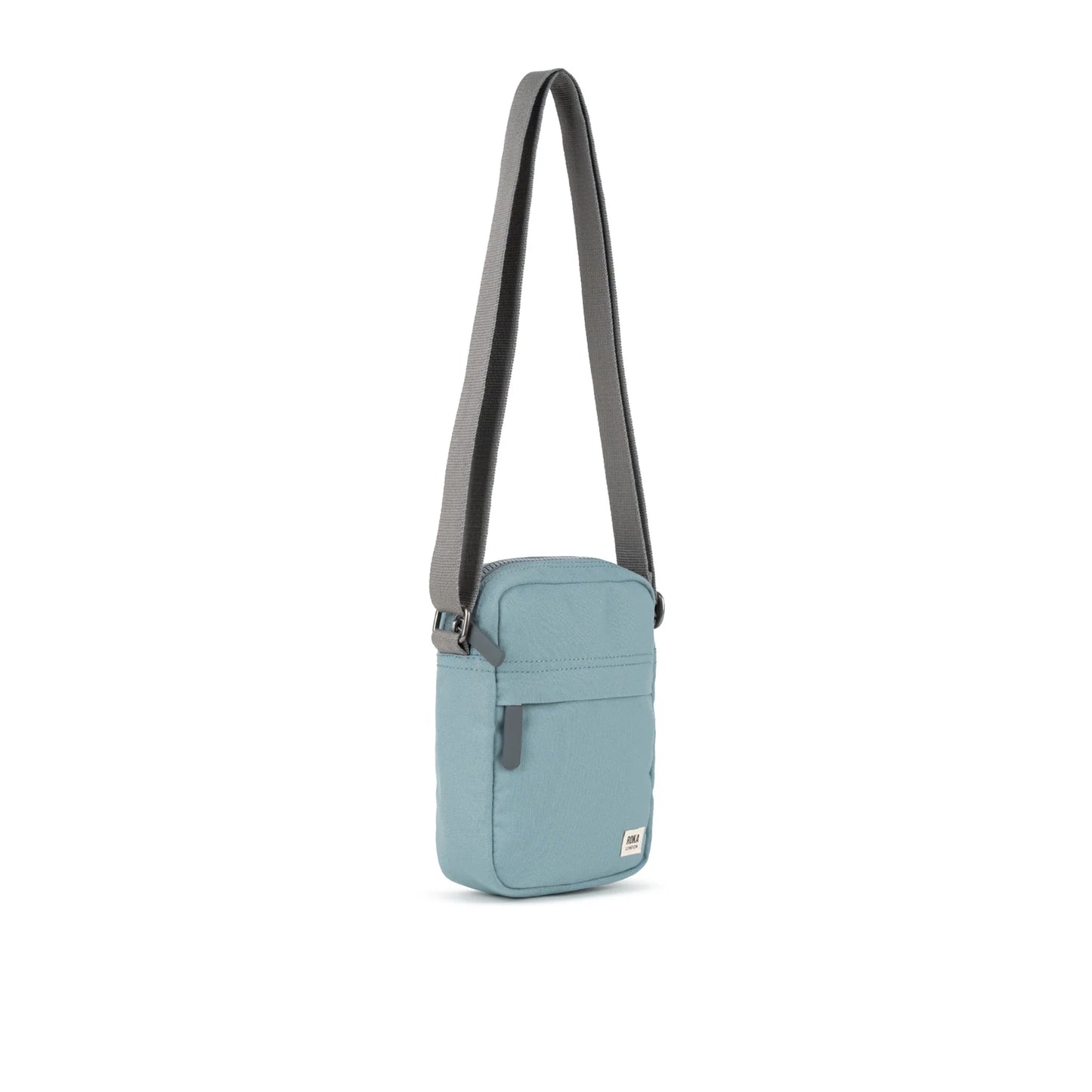 A small crossbody bag in canvas material and a light blue colour side view