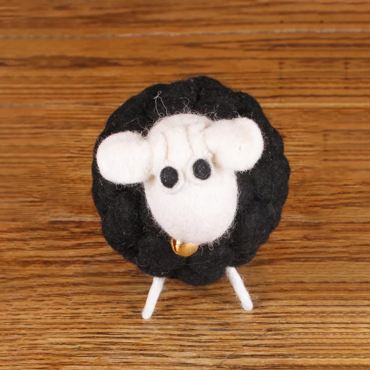 Black and white felted sheep figure with bell