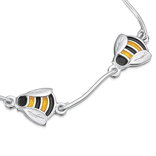 zoomed image of polished silver multi-link bracelet with enamelled black and yellow bees with silver rod spacers