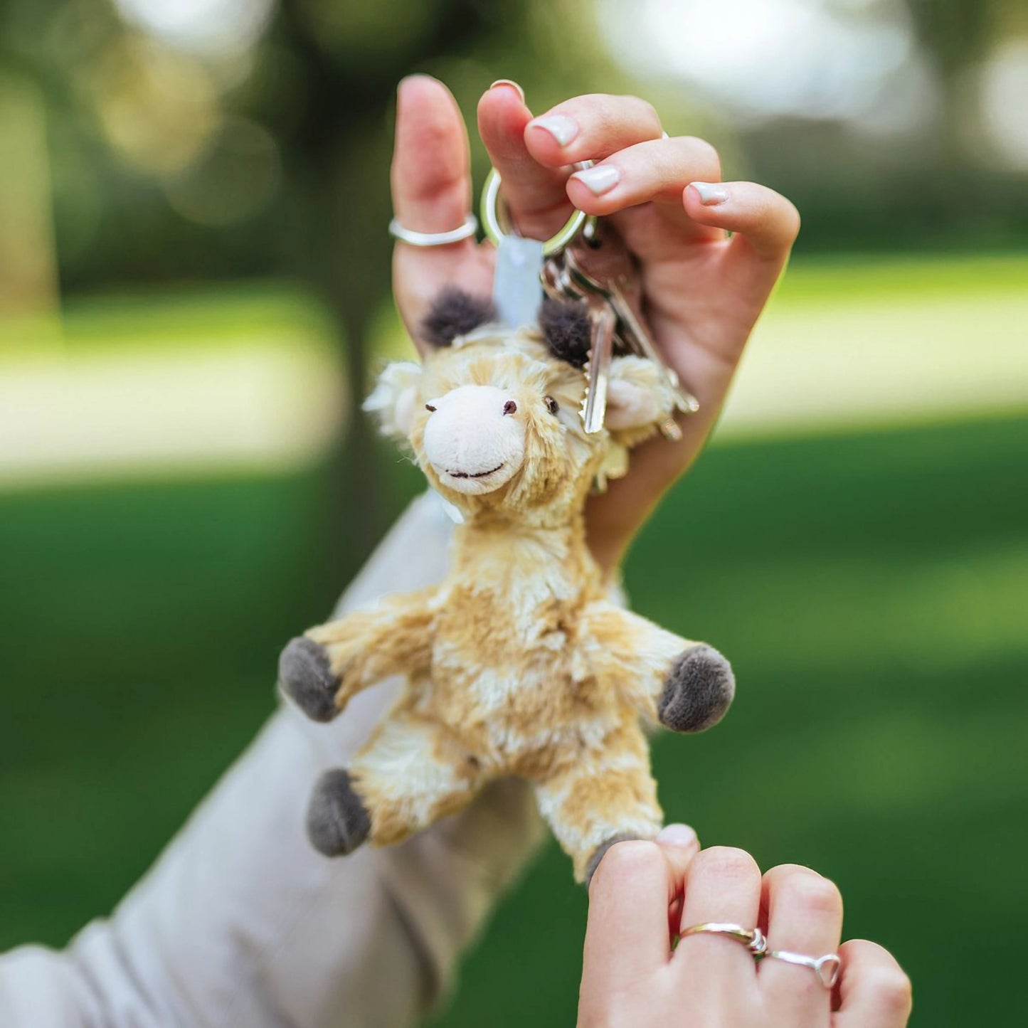 Model holding a plush giraffe keychain