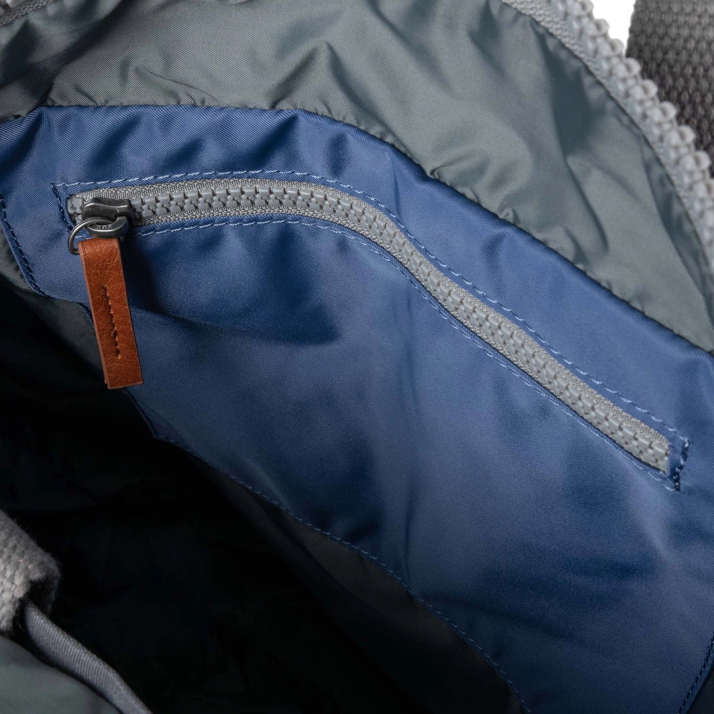 Blue rolltop backpack with grey interior zip