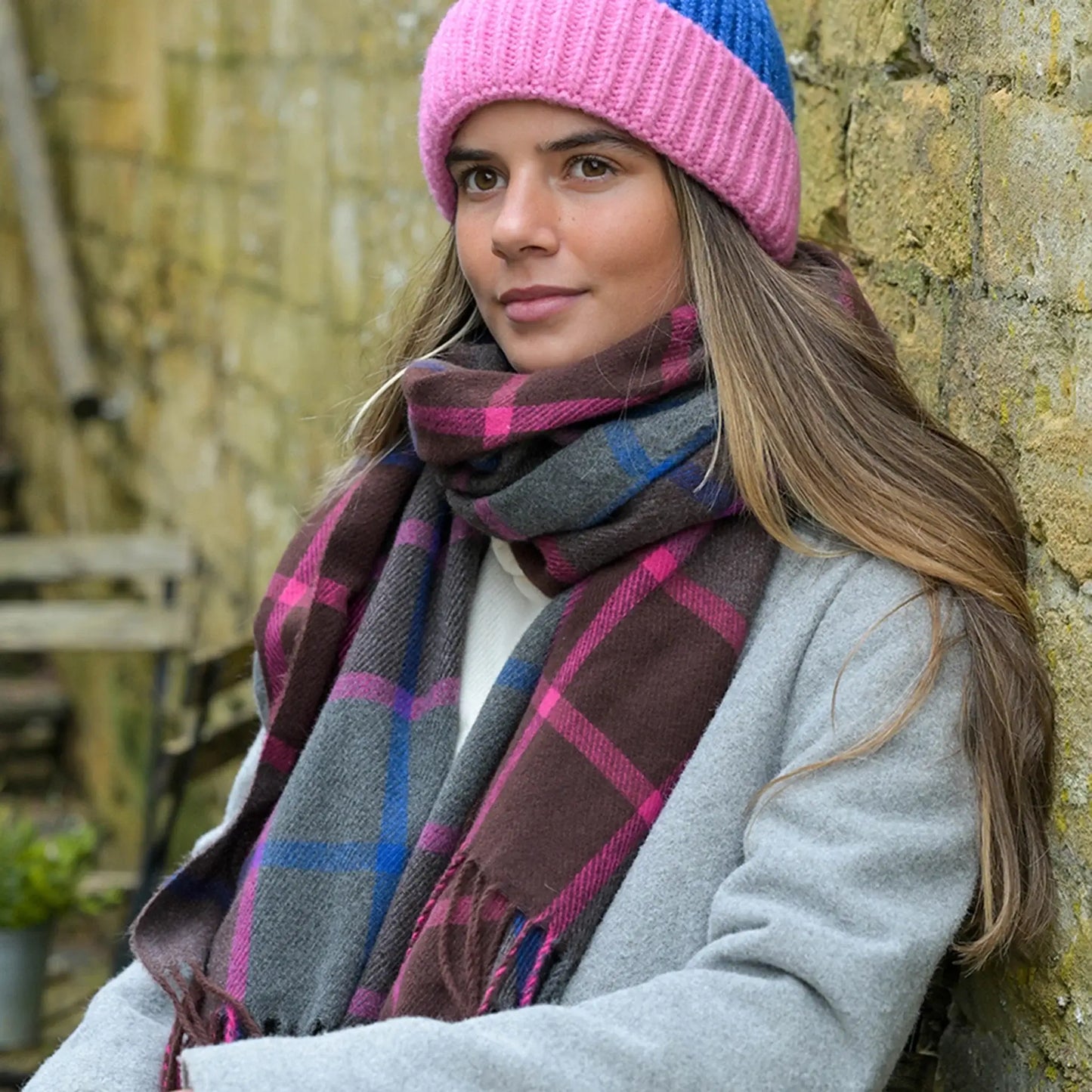 Model wearing check scarf in blue, purple and grey with tassel trim