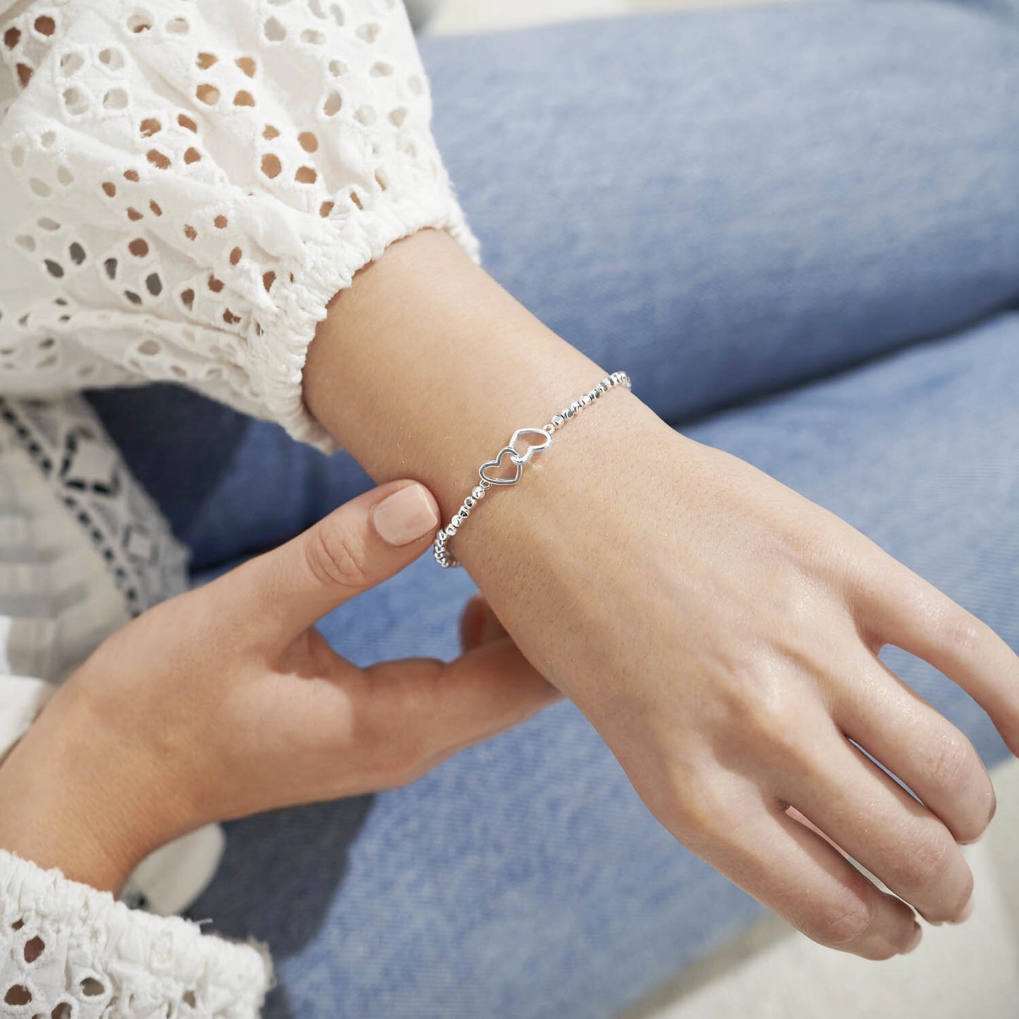 Model wearing a silver beaded bracelet with silver interlinking circles