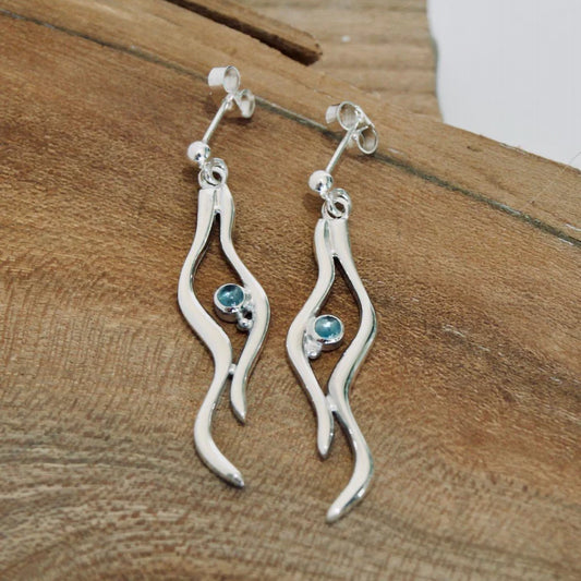 Silver drop earrings featuring a double ripple design with a round blue topaz stone