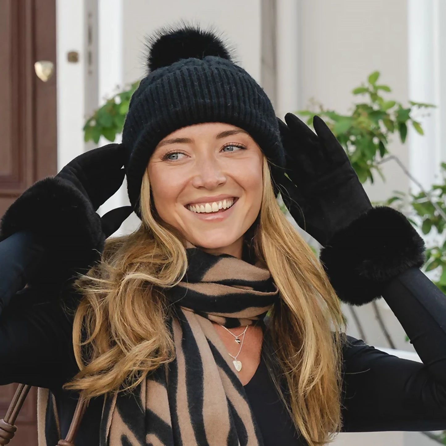 Model wearing a pair of faux suede gloves with fur cuffs in black