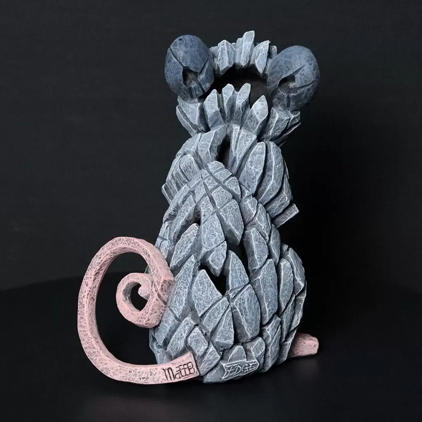 Modern sculpture of a grey field mouse with a raspberry back view