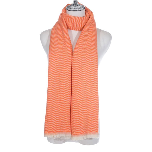 A long bright orange scarf with chevron pattern and short white fringe