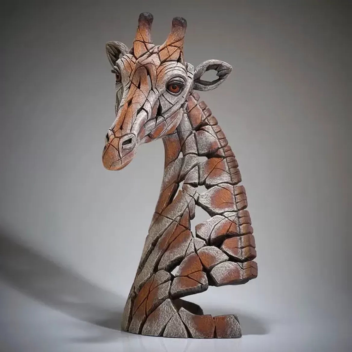 A textured and painted giraffe head bust sculpture side view