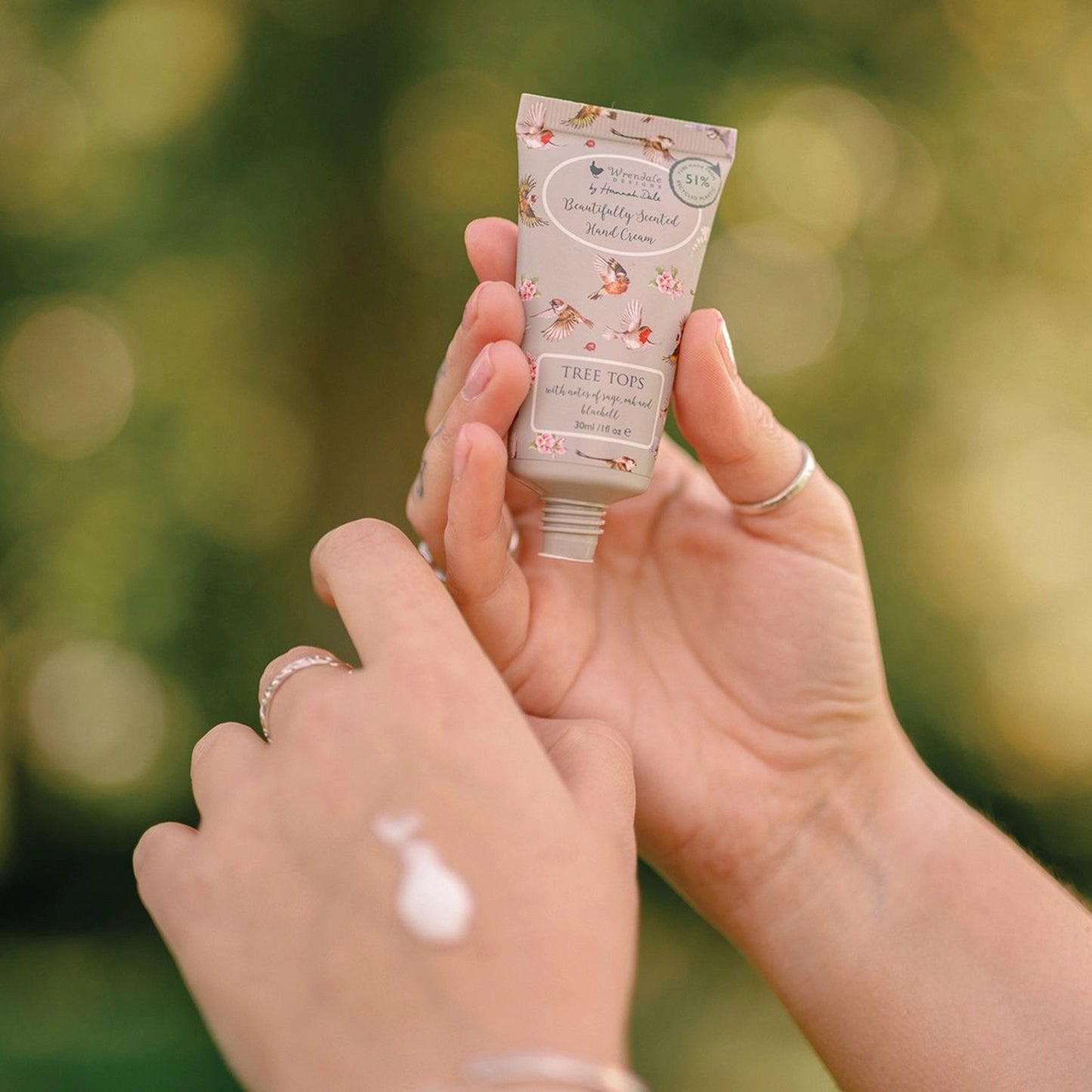 Small grey hand cream tube decorated with bird illustrations lifestyle