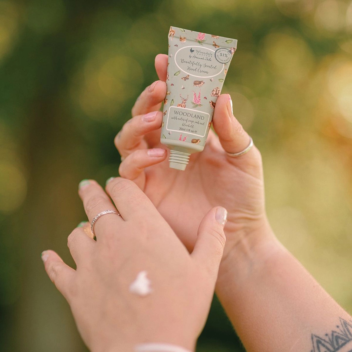 Small green hand cream tube decorated with woodland creature illustrations lifestyle