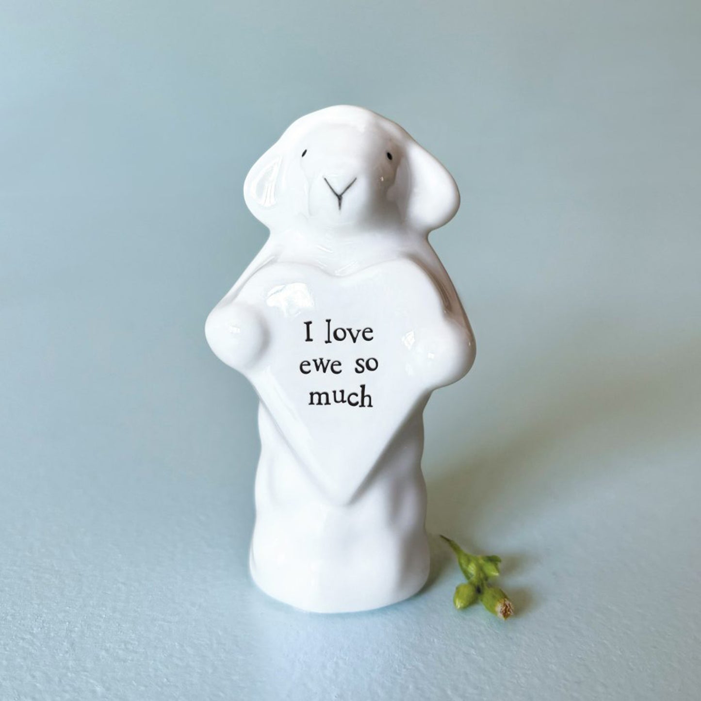 A sheep figure holding a heart plaque with the words 'I love ewe so much'