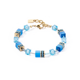 A bracelet in gold steel with blue cube stones and beads