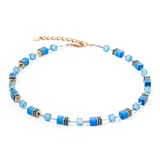 A gold steel necklace featuring cube stones and glass beads in blue