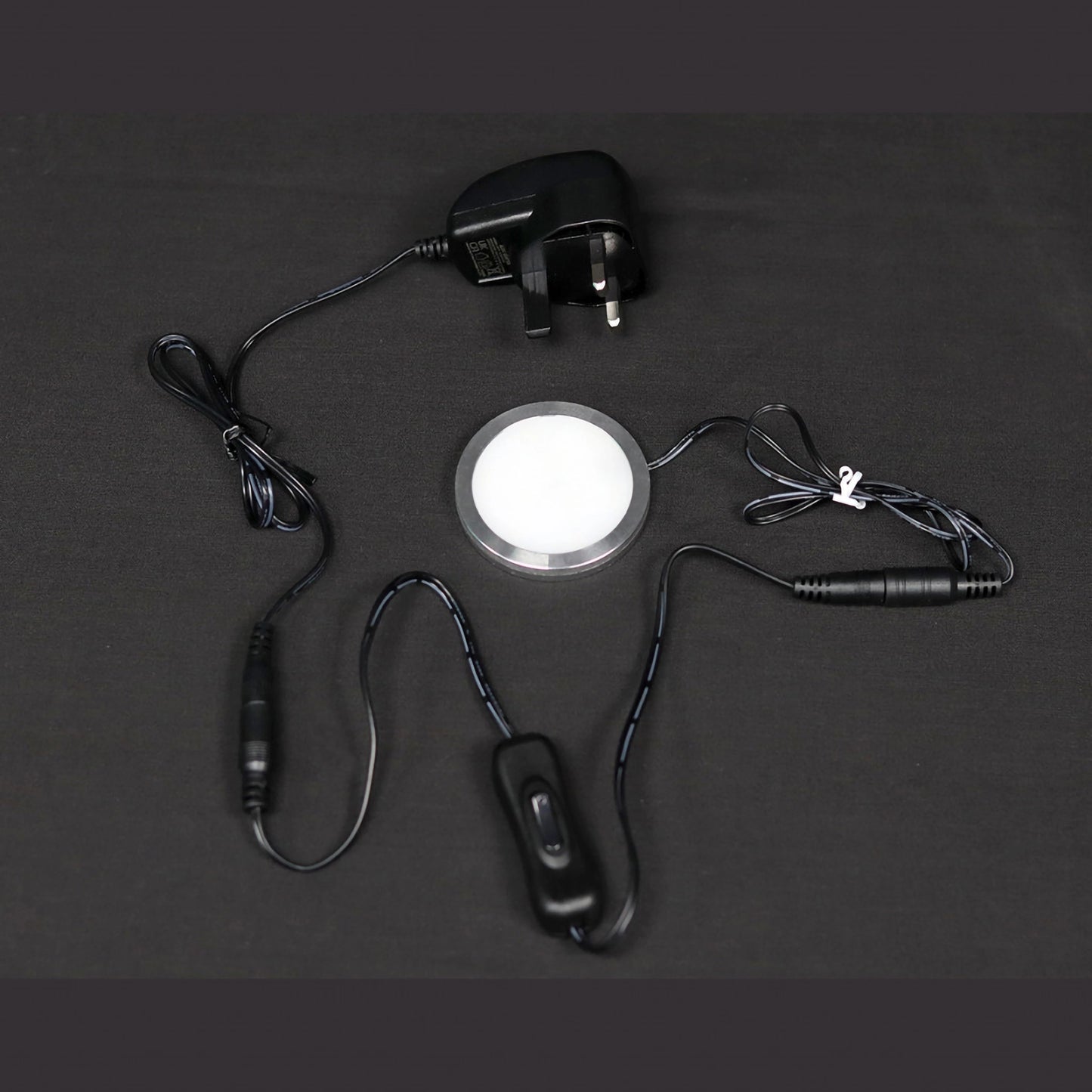 A UK 3-Pin plug adaptor with rocker clasp and disc light