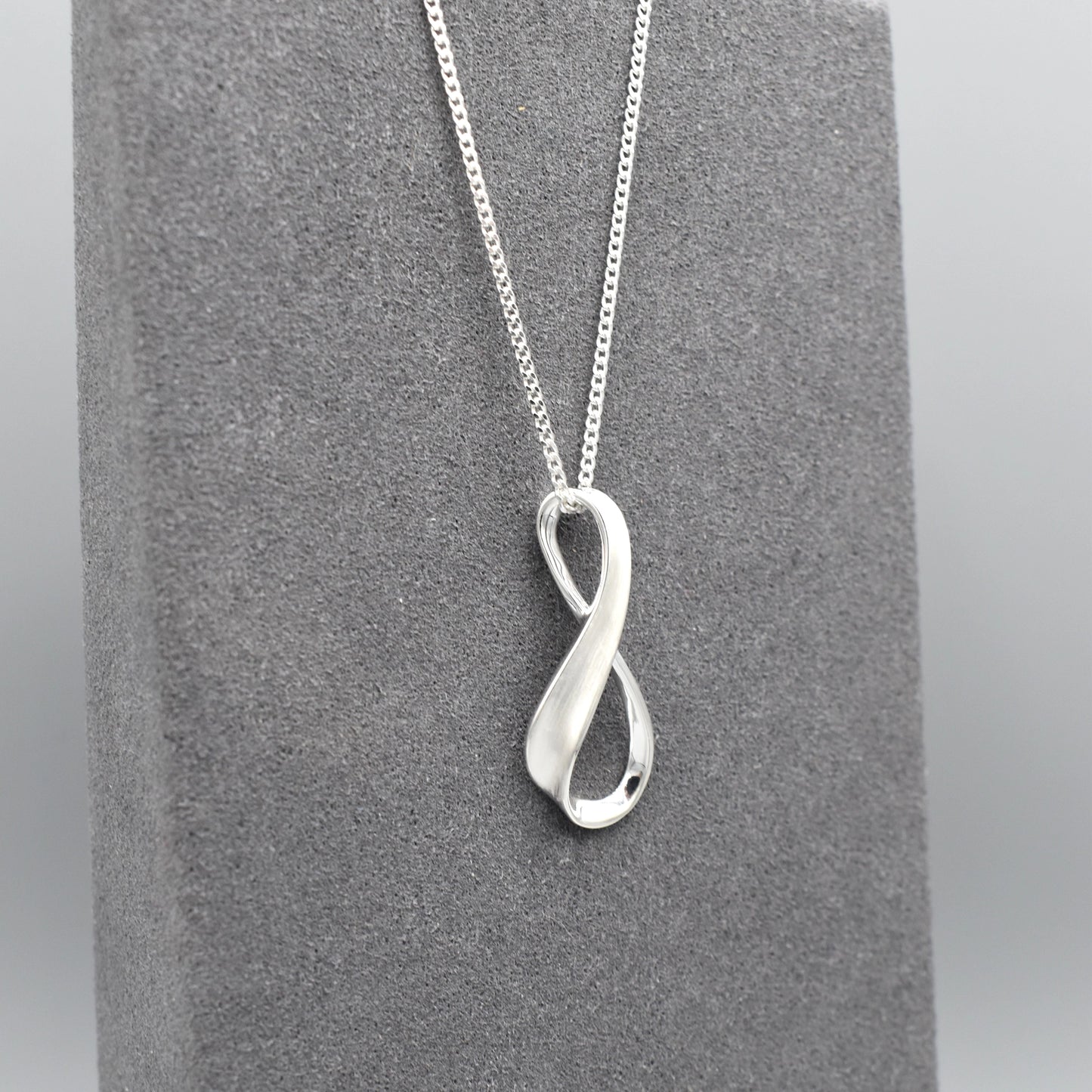 A silver matt & shiny infinity symbol shaped pendant