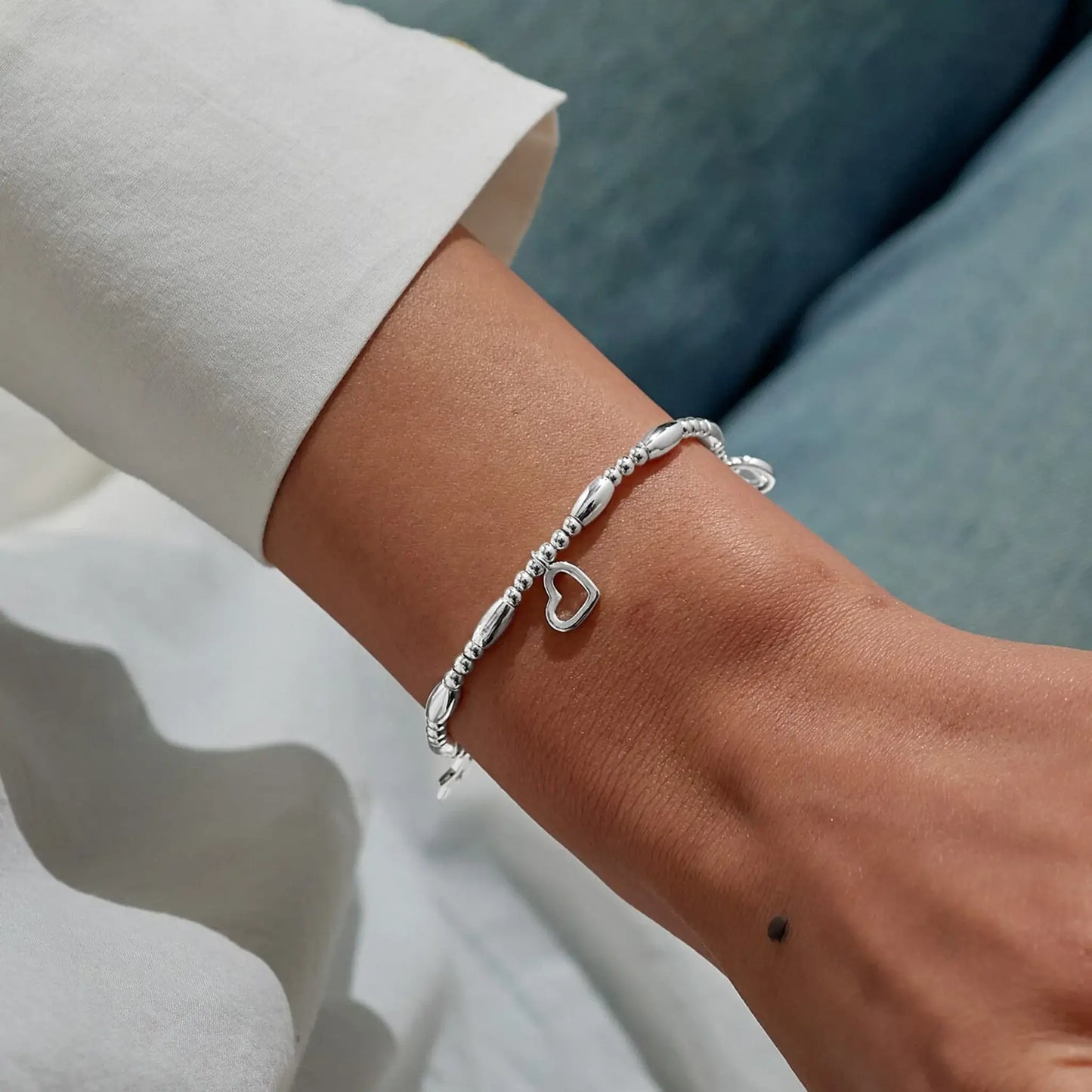 A beaded stretch silver bracelet with two different heart charms and a star model