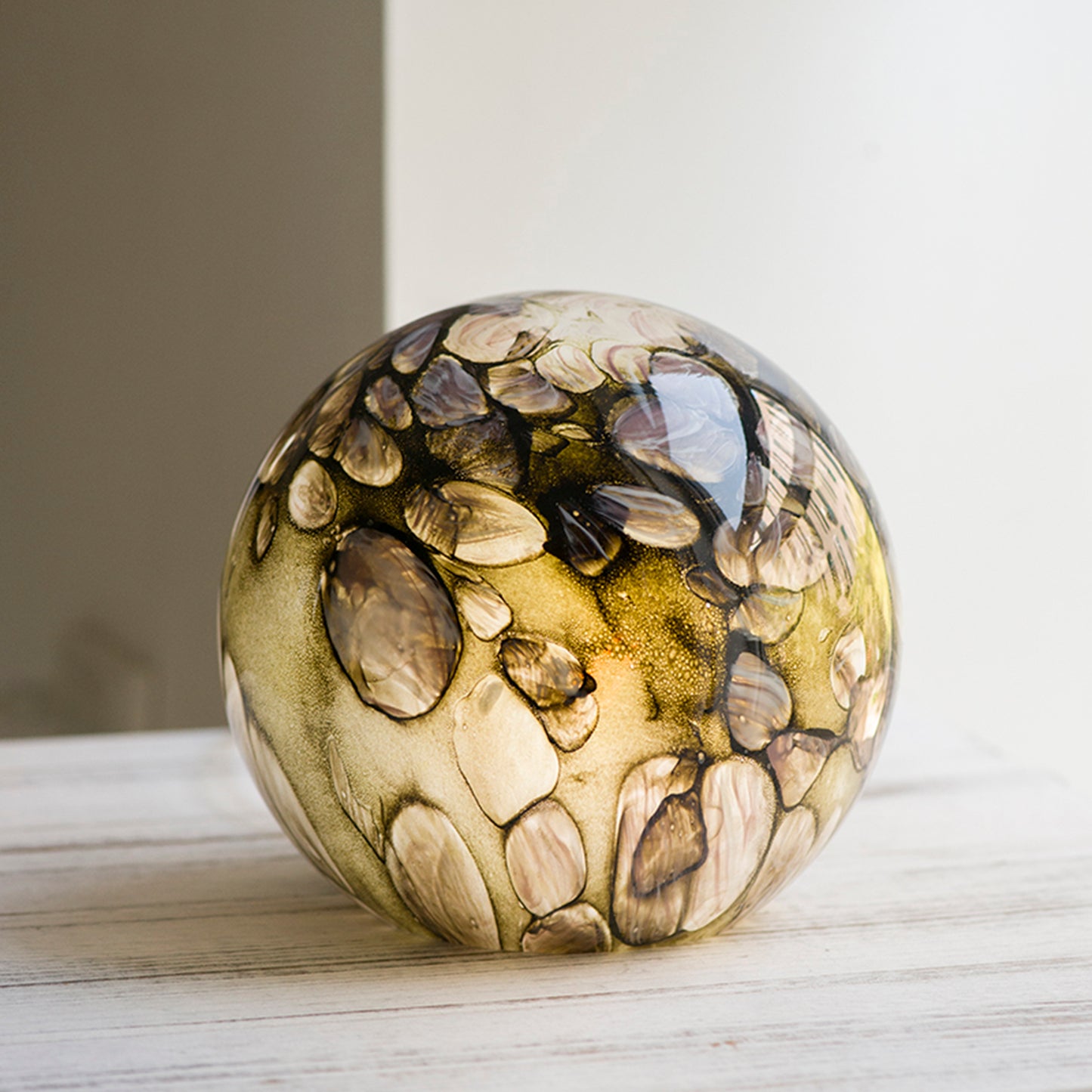 A round glass lamp with a design based on sun dappled rivers