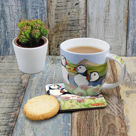 A mug fully illustrated with a watercolour artwork of puffins by the water lifestyle