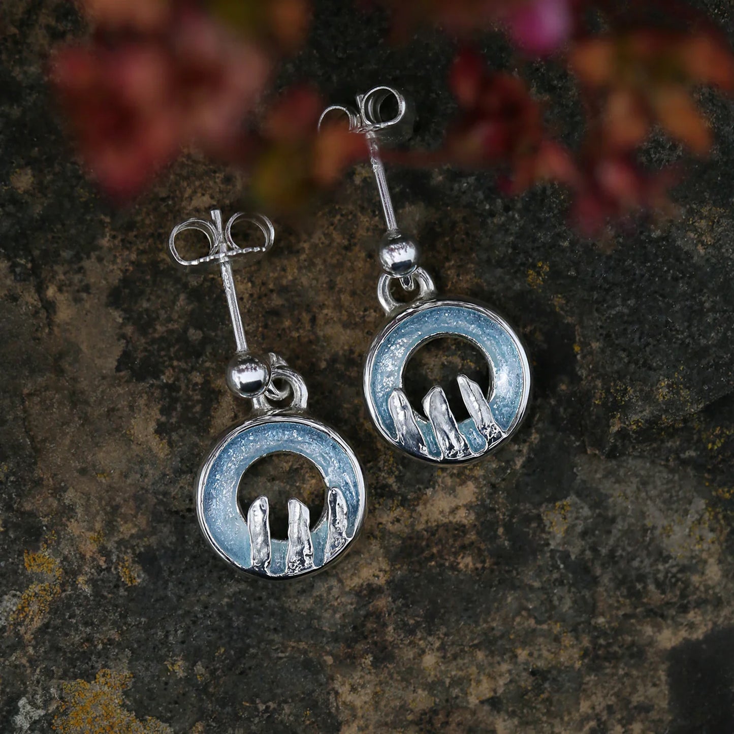 Silver drop earrings with round open circles in blue grey enamel, finished with a standing stone design - lifestyle