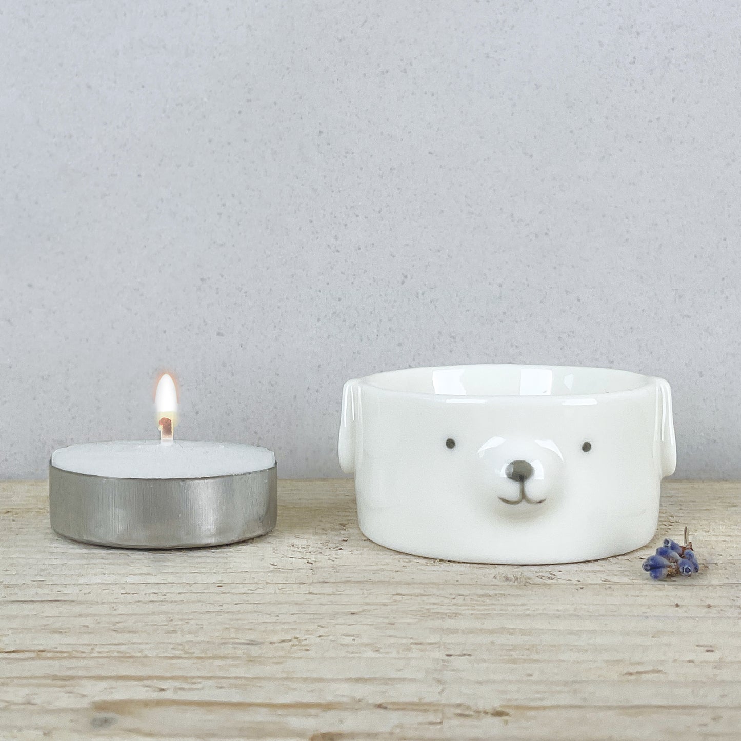 A white ceramic dog tealight holder