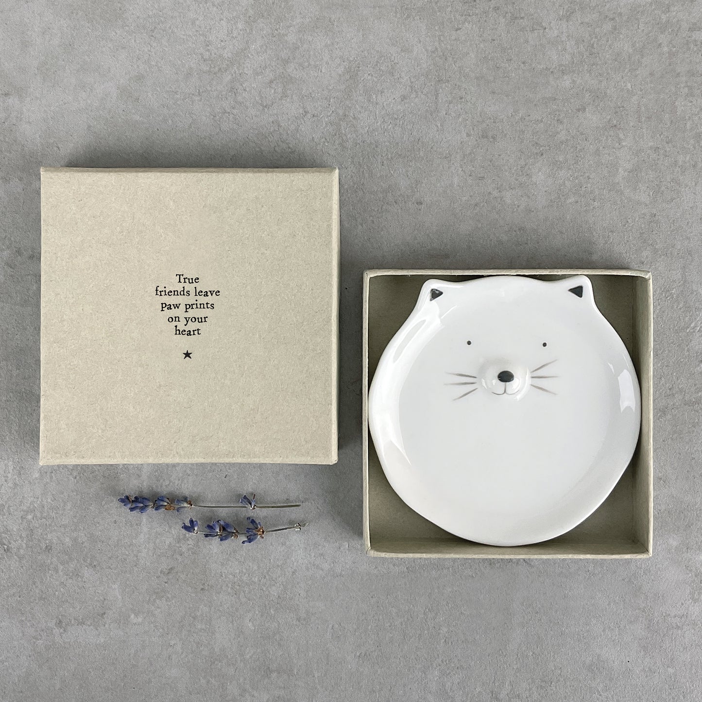 A round white ceramic trinket dish with a cat face and ears in a box