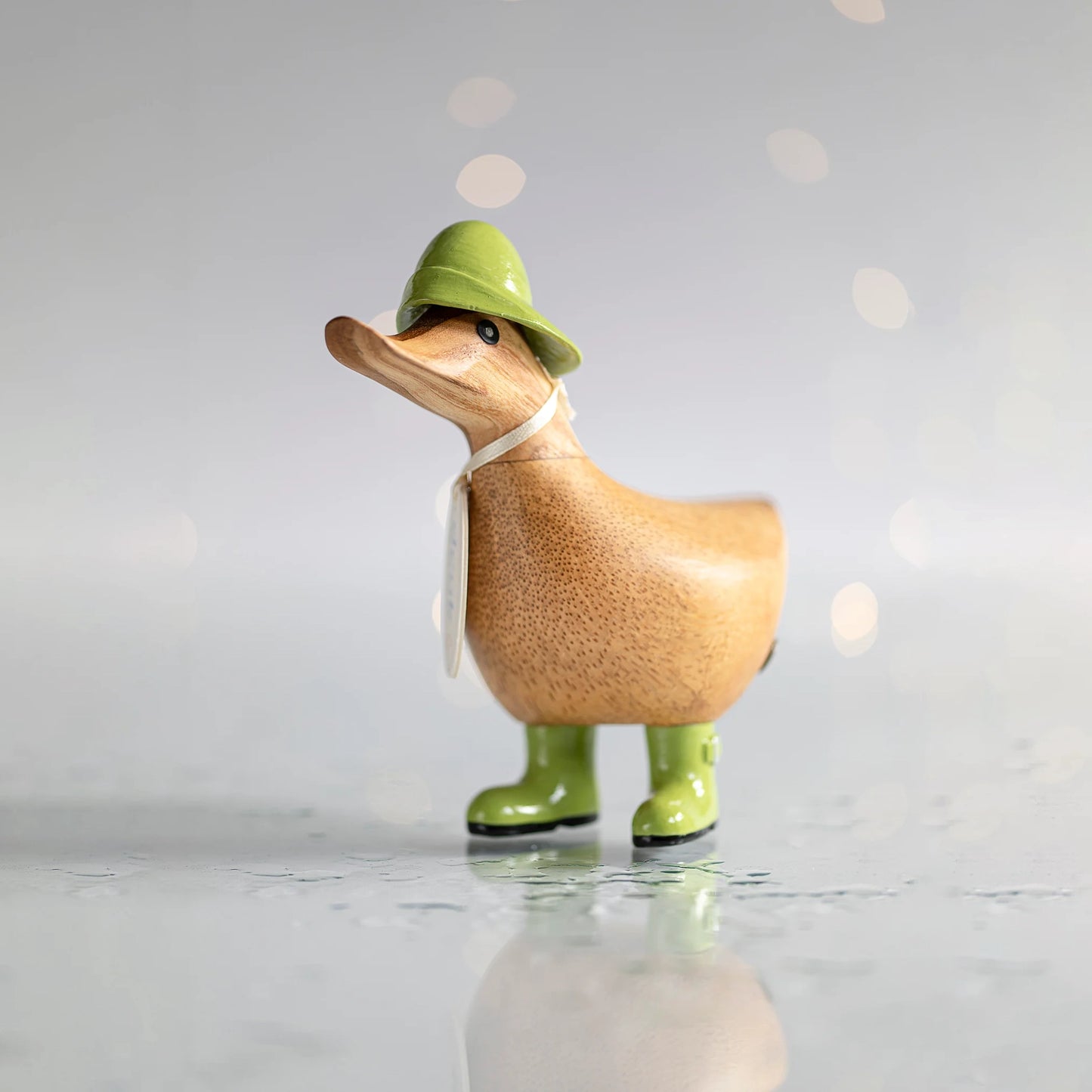 Wooden duck collectible figure in green rain hat and boots