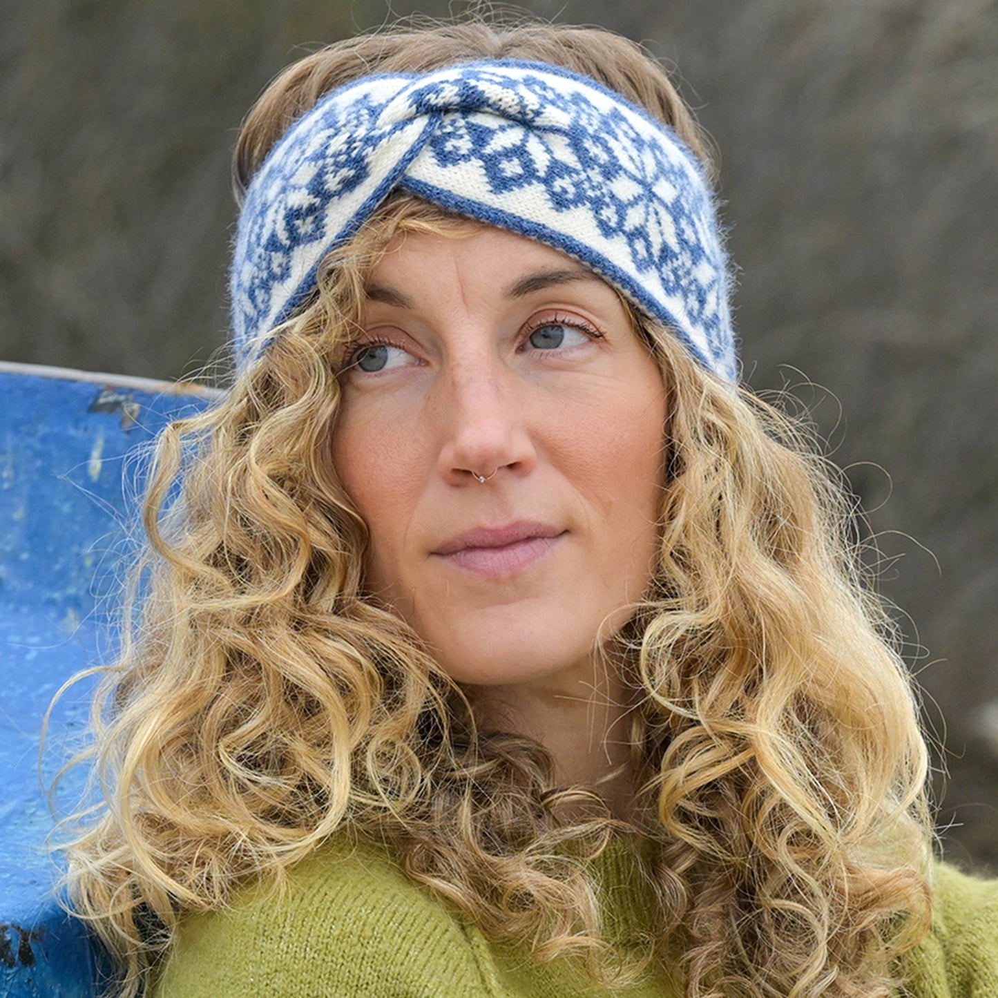 Model wearing Scandi style star patterned knitted headband in blue and cream with twist detail front