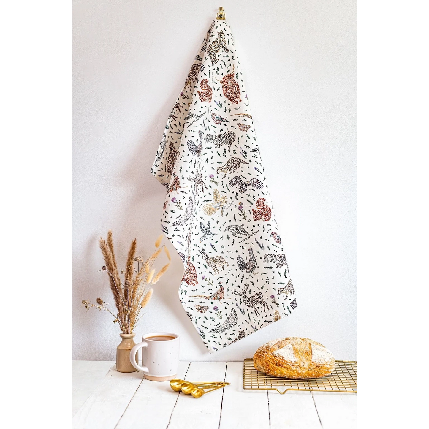 White cotton tea towel with Scottish wildlife design in florals lifestyle