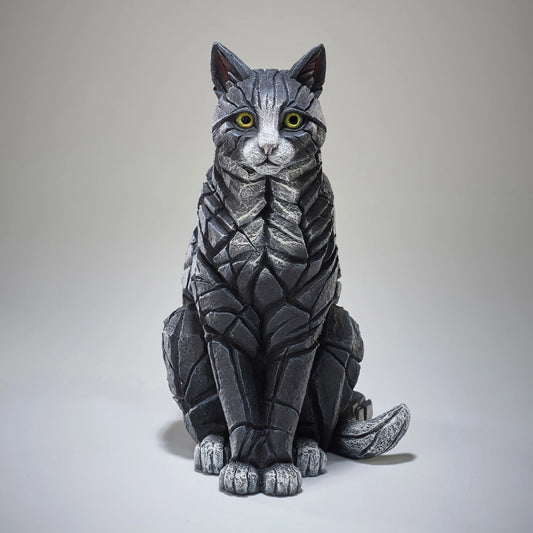 Front view of a modern sculpture of a sitting black and white cat