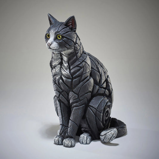 Side view of a modern sculpture of a sitting black and white cat