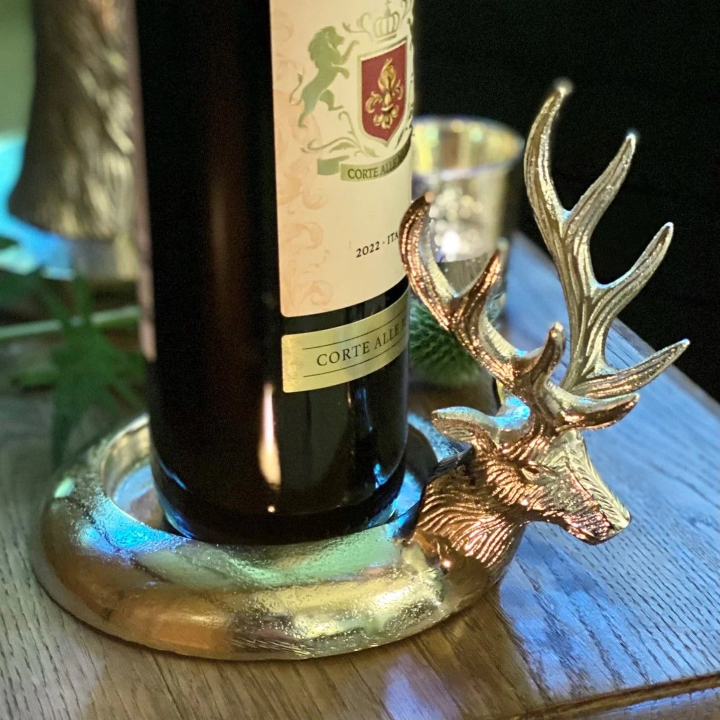 An aluminium bottle coaster with raised sides and a 3D stag head detail