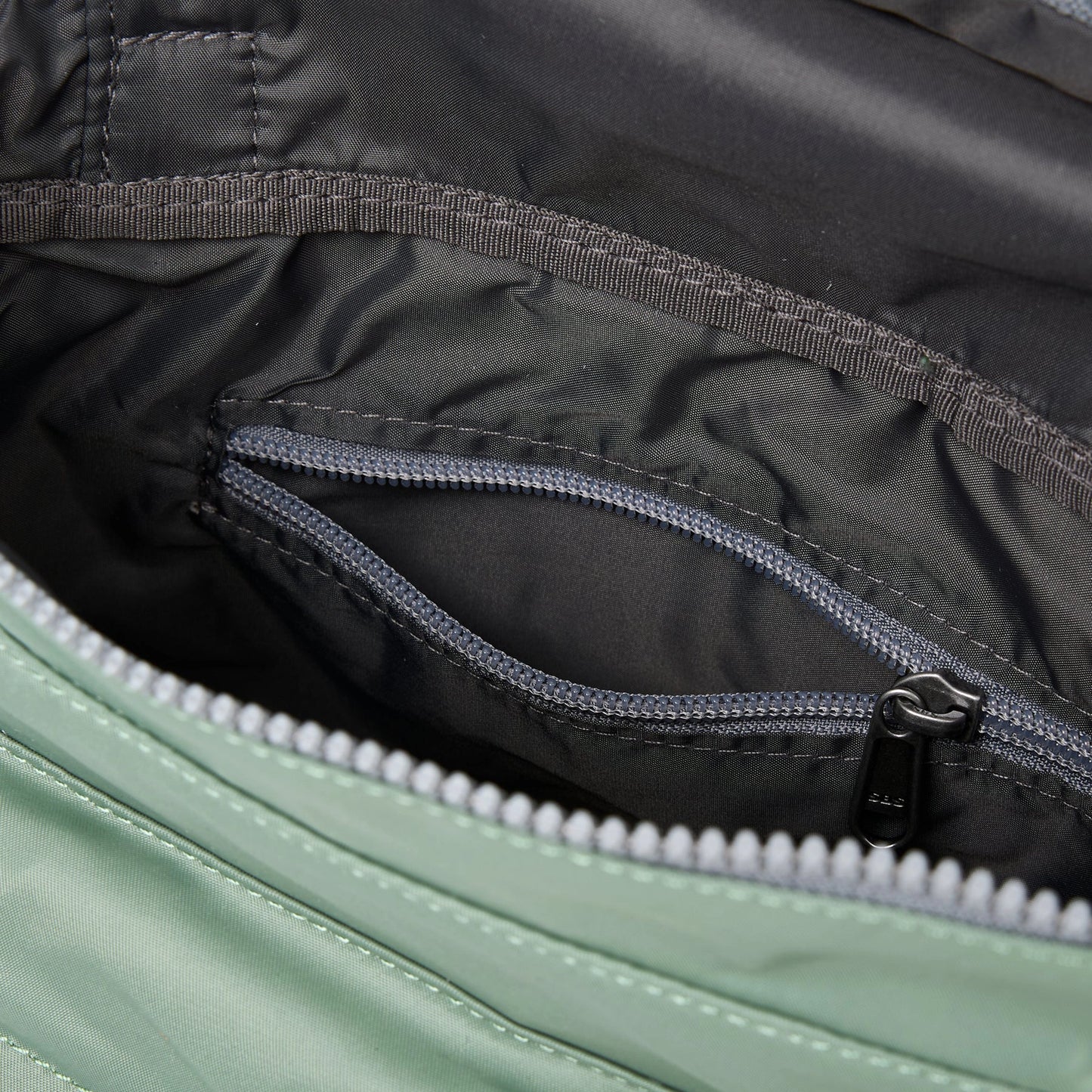 A square mint green nylon bag with grey internal zip pocket